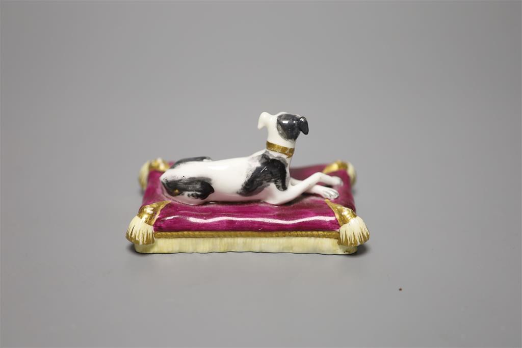 A Minton porcelain greyhound, recumbent on cushion, width 20cm